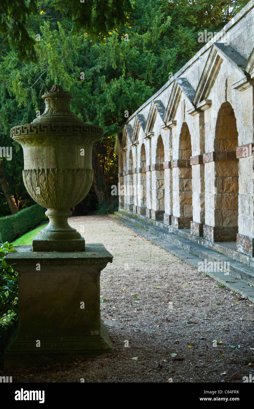 Les sept arcade voûtée par William Kent en regard d'une urne classique en pierre richement à Rousham House, Oxfordshire, Angleterre Banque D'Images