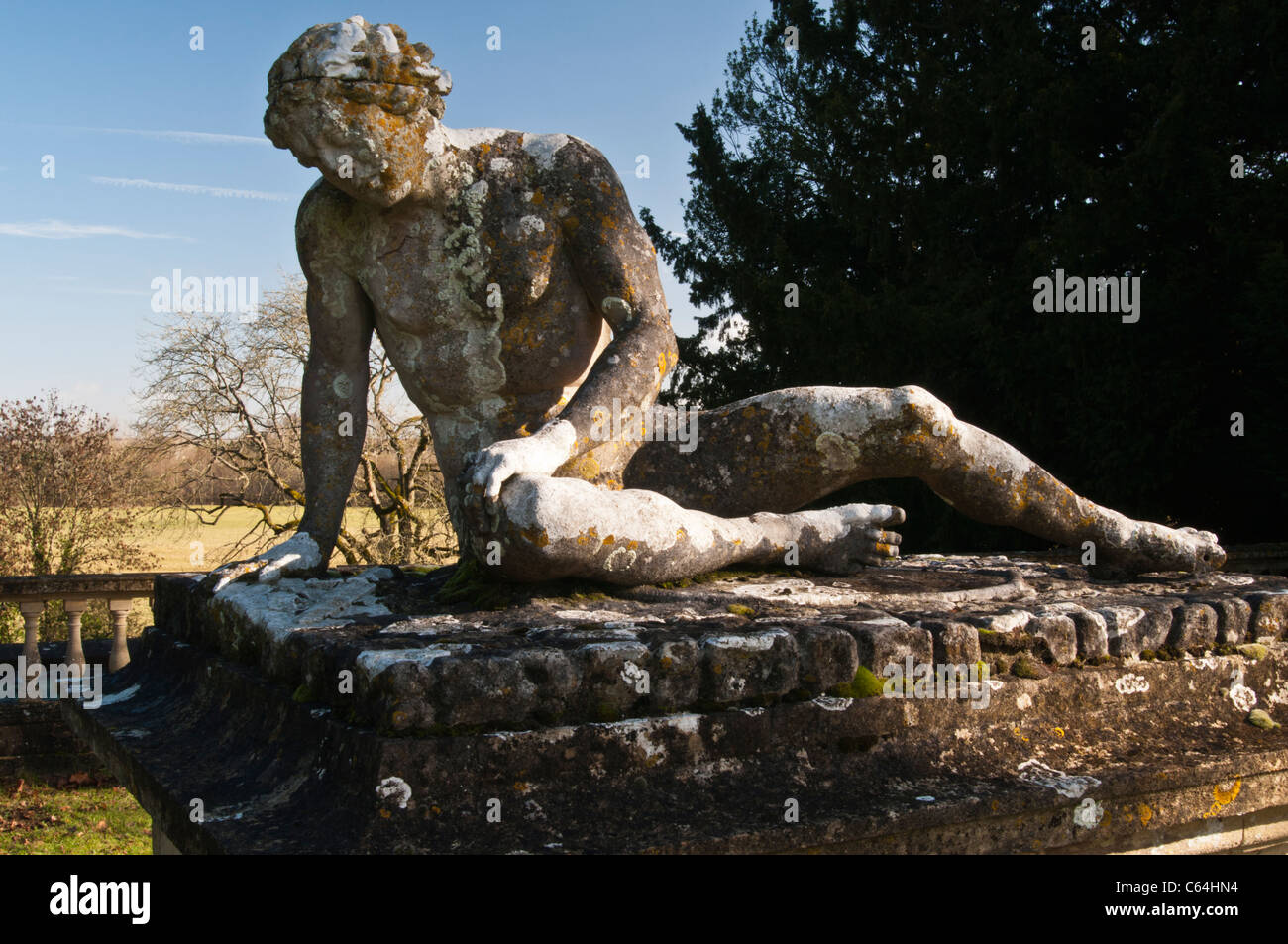 La statue couverte de lichen du « gladiateur de glace » de Scheemaker, baignée par le soleil d'hiver chaud à la maison de Rousham, Oxfordshire, Angleterre Banque D'Images