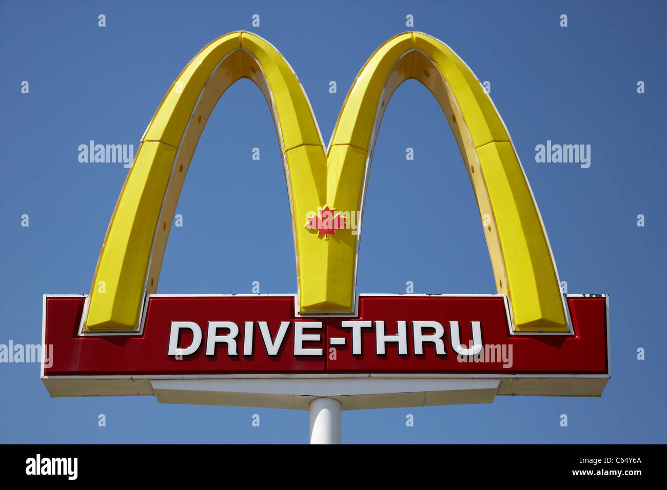 Mcdonalds arches d'or avec le symbole de la feuille d'érable rouge sur drive-thru sign in Saskatoon Saskatchewan Canada Banque D'Images