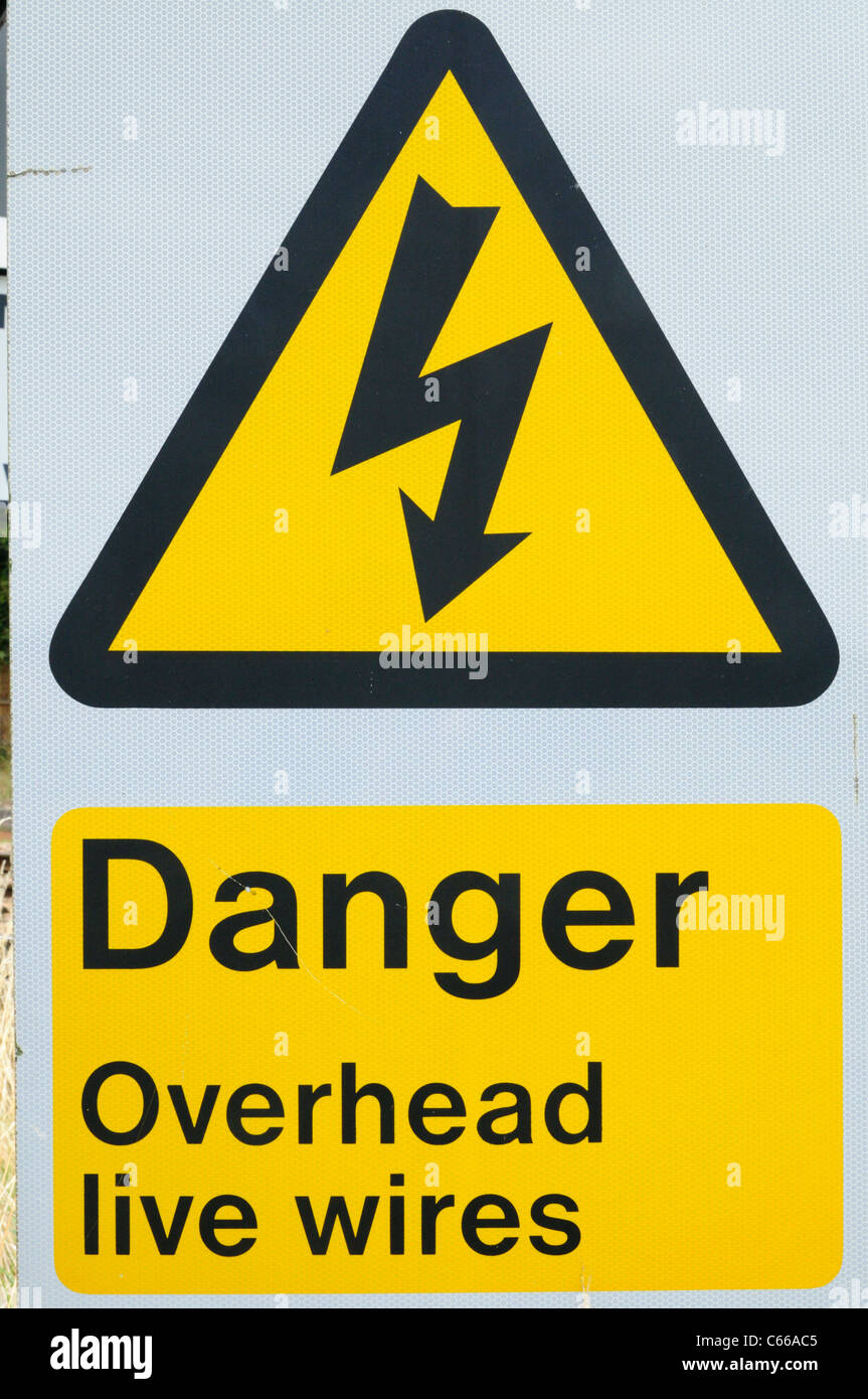 Les frais généraux de danger Live Wires Panneau d'avertissement à côté d'une ligne de chemin de fer, Shepreth, Cambridgeshire, Angleterre, RU Banque D'Images