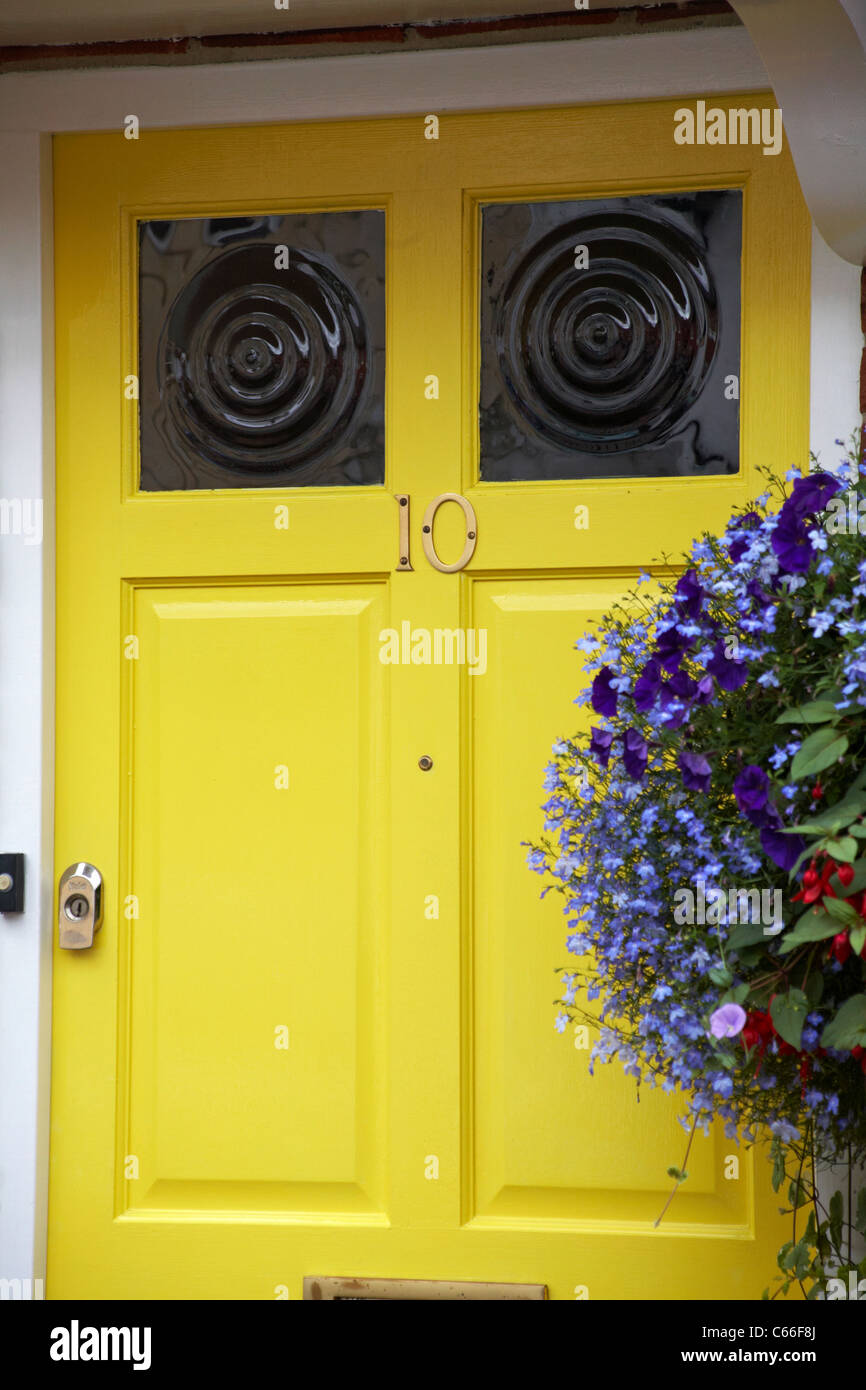 Porte avant jaune du numéro 10 Middlebridge Street avec panier suspendu à Romsey, Hampshire, Royaume-Uni en août Banque D'Images