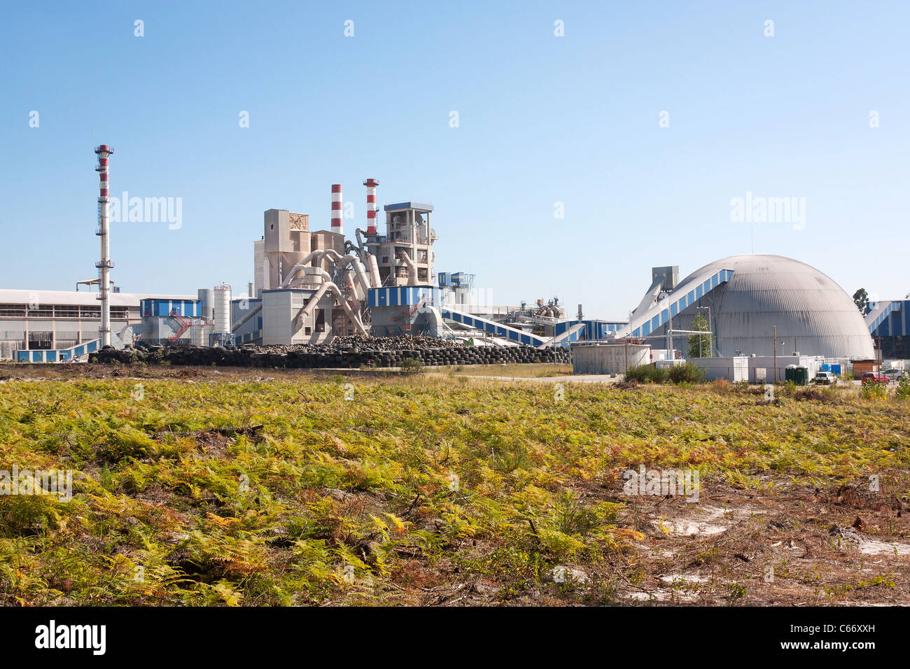 L'usine de caoutchouc intégré dans le paysage contre le ciel bleu Banque D'Images