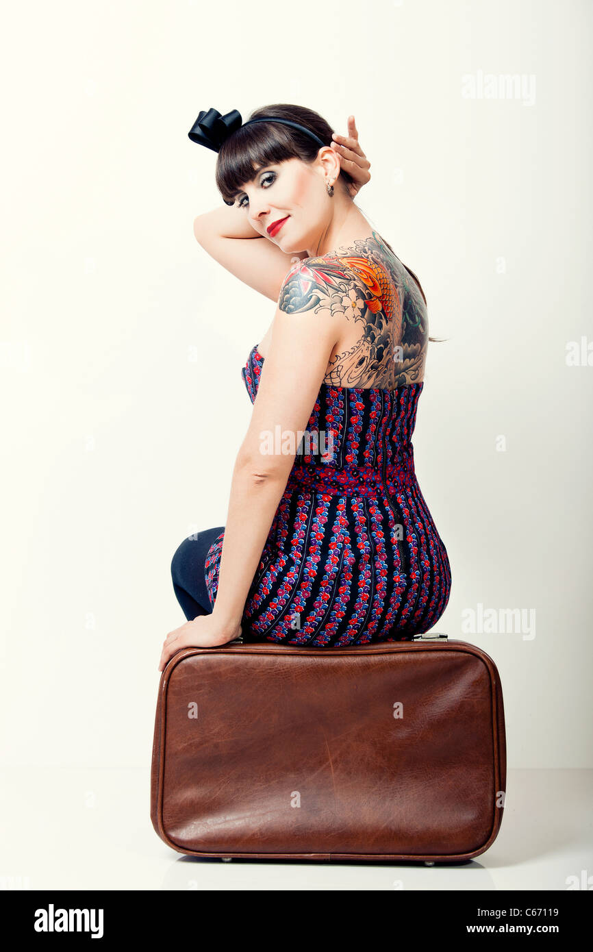 Portrait en gros plan d'une belle femme avec un style vintage assis sur un sac Banque D'Images