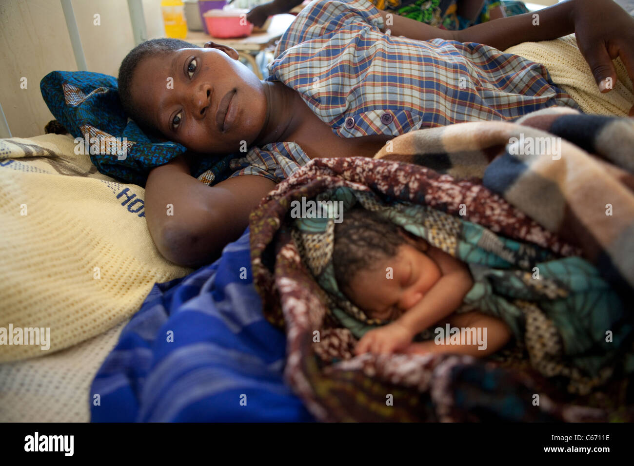 Une mère et son enfant nouveau-né allongée dans son lit, dans l'unité anti-natal de l'hôpital de Dedza, Malawi, Afrique du Sud. Banque D'Images