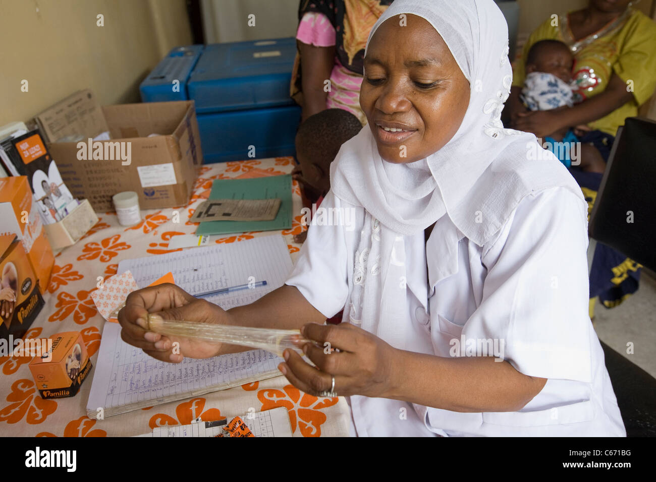 Une femme montre l'utilisation d'un préservatif dans une clinique de planning familial à Dar es Salaam, Tanzanie, Afrique de l'Est. Banque D'Images