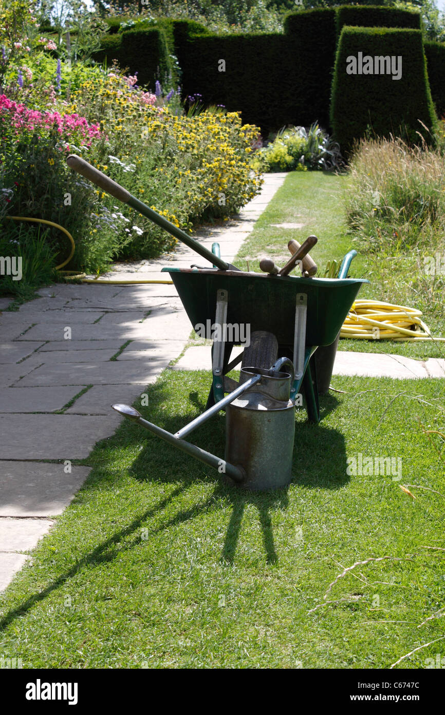 BROUETTE PITTORESQUE AVEC DES OUTILS DE JARDINAGE. Banque D'Images