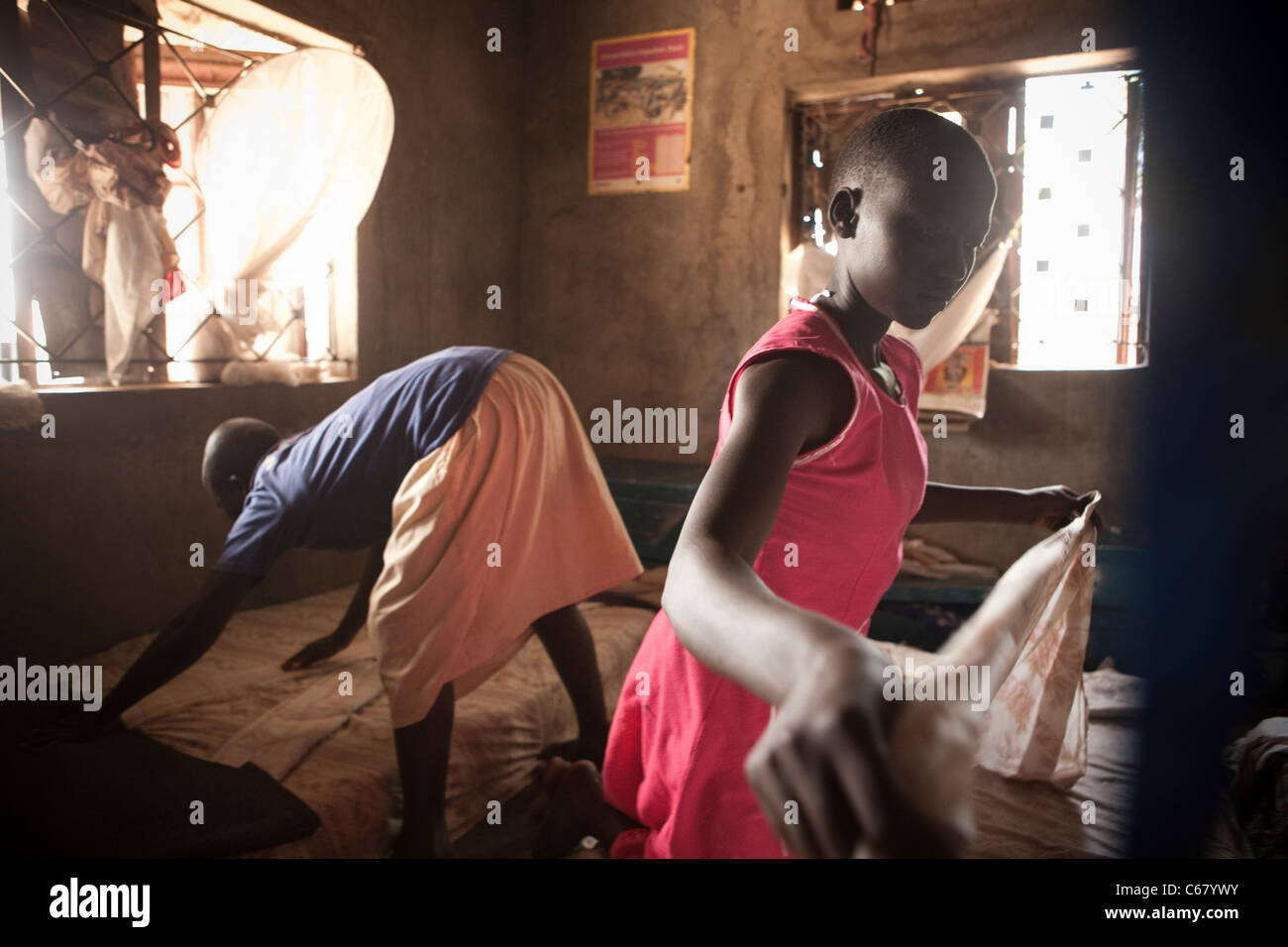 Les enfants font leur lit dans un dortoir à l'école, de l'Ouganda Amuria, Afrique de l'Est. Banque D'Images