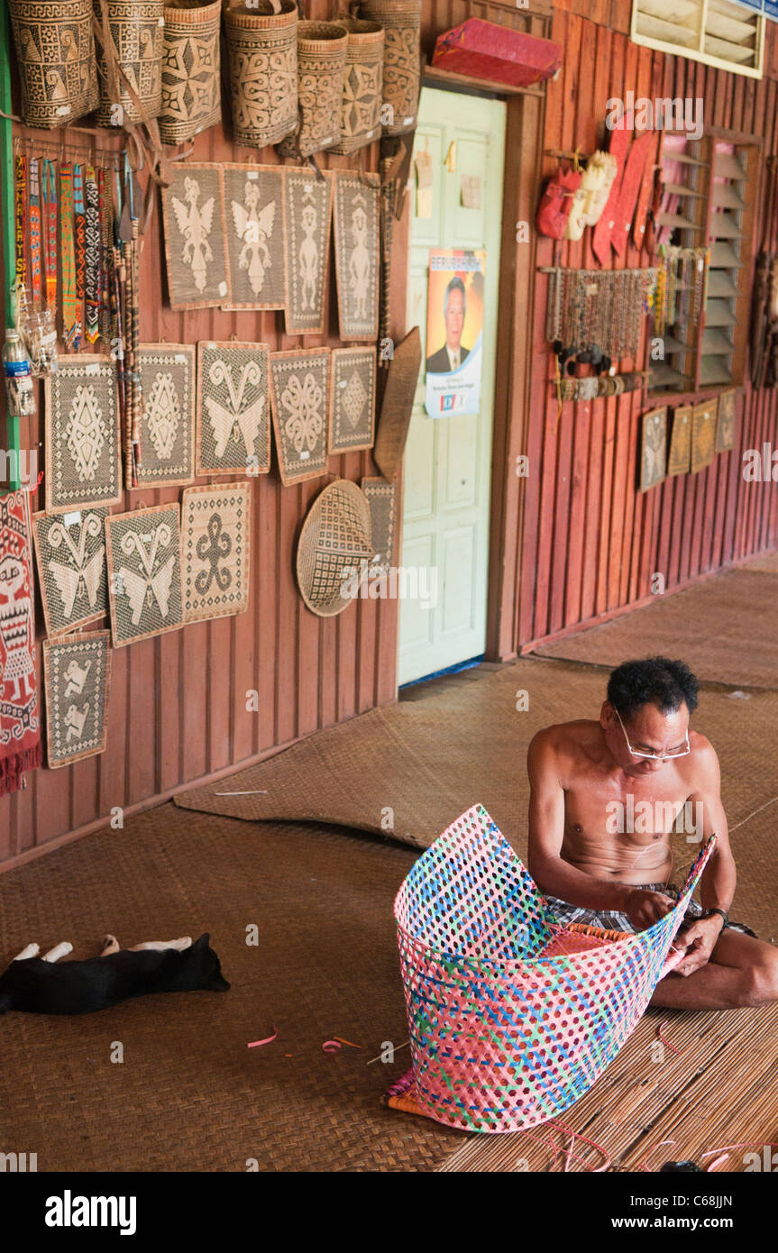 Homme Iban tisser un panier dans la Nanga Sumpa longhouse au Sarawak, Bornéo, Malaisie Banque D'Images