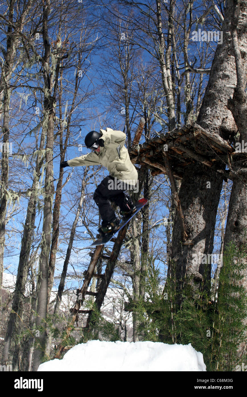 Snowboarder Jumping off tree fort à Termas de Chillan ski resort. Biobio, Chili, Amérique du Sud Banque D'Images