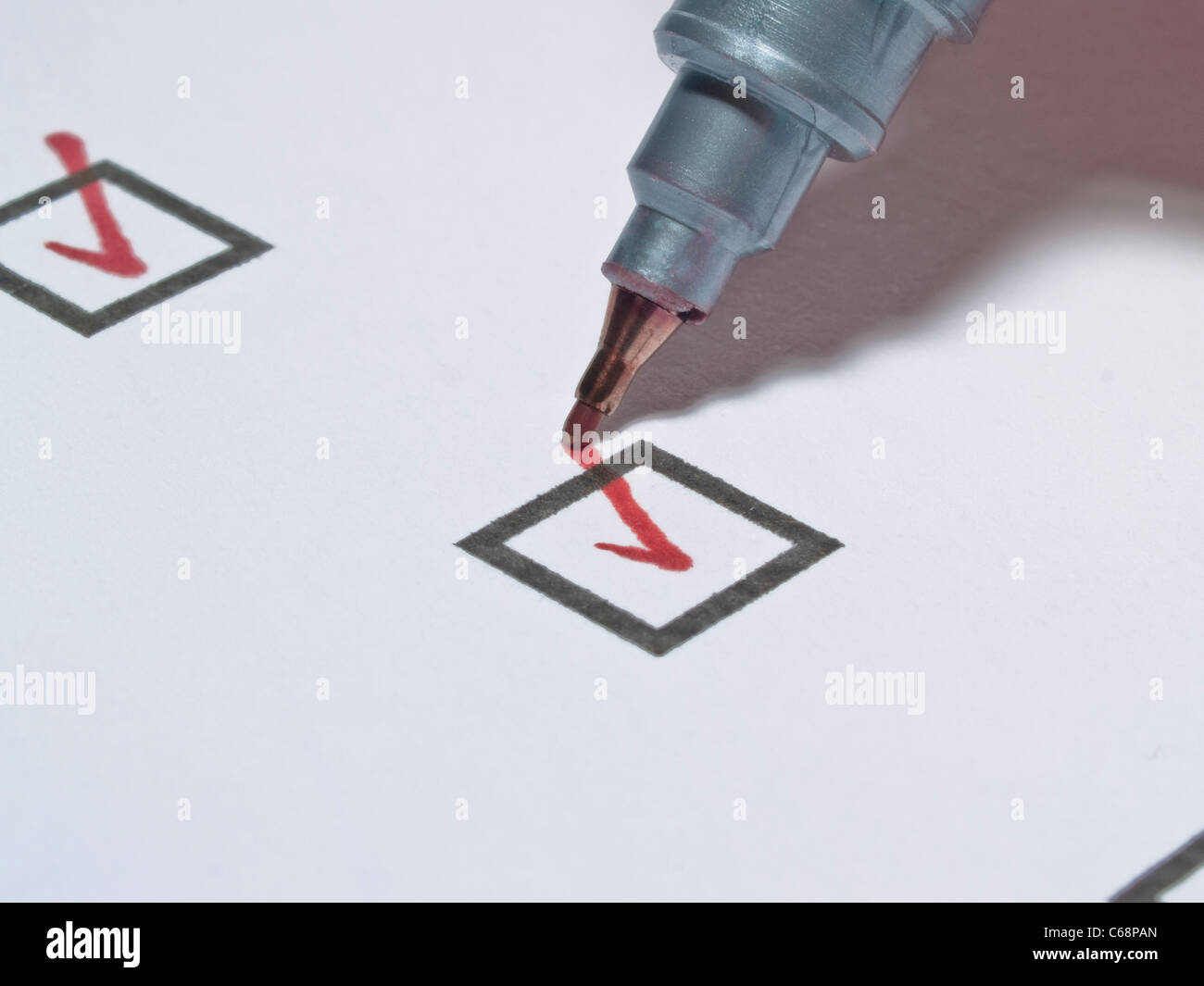 Ein roter Stift hakt eine Kästchen mit à écrire un ab | une broche rouge fait un chèque dans une petite boîte dans une liste Banque D'Images