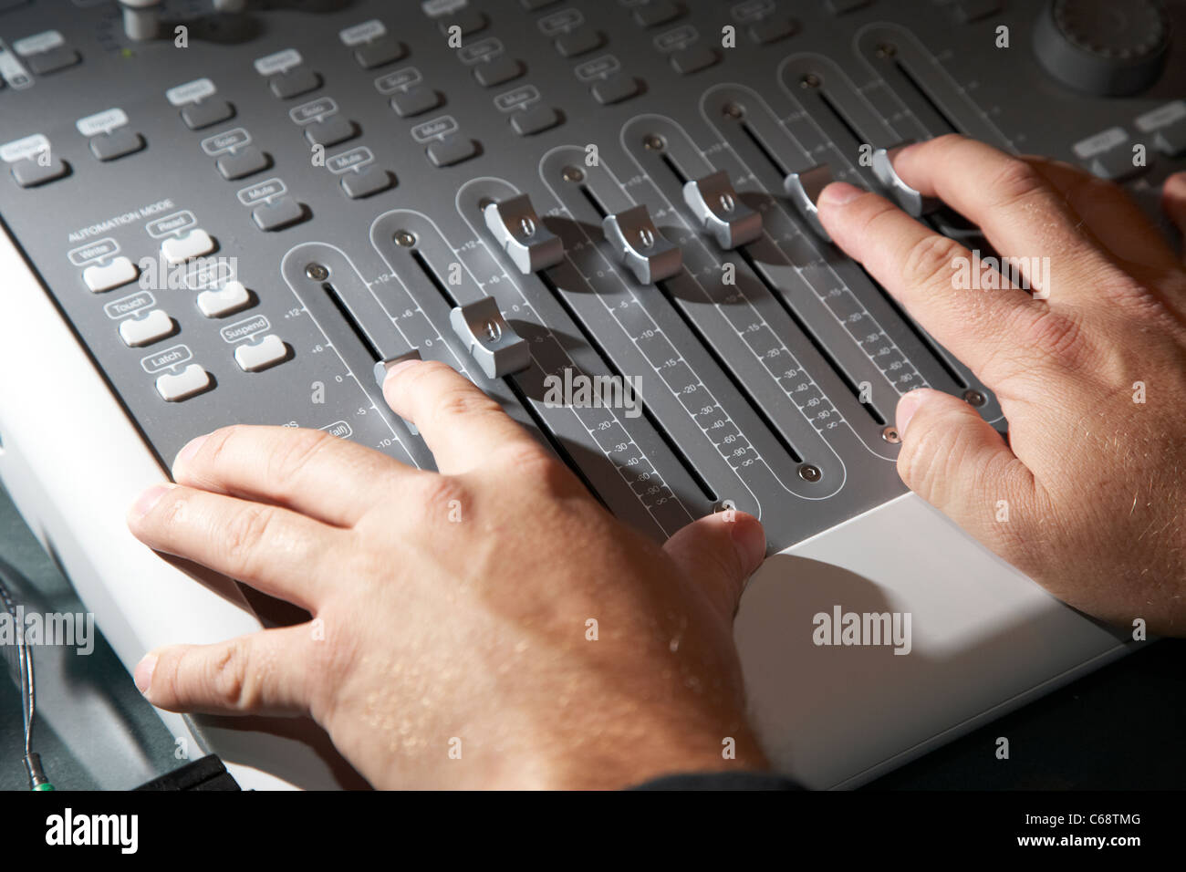 Les mains d'ingénieurs du son travaillant sur une platine de mixage dans un studio d'enregistrement Banque D'Images