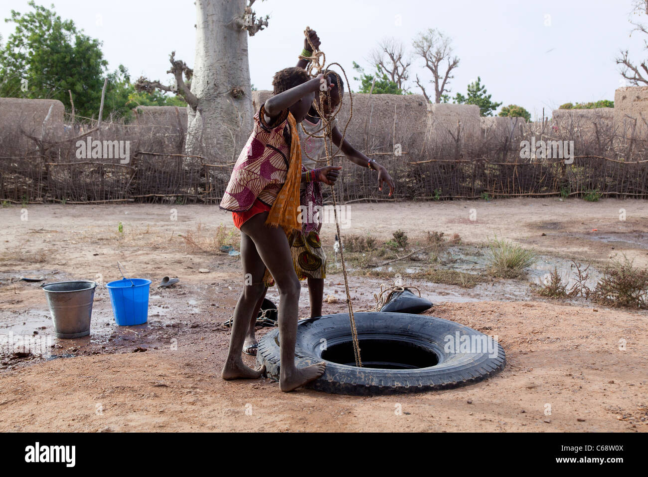 Deux jeunes filles de l'eau d'un puits dans un village au Mali l'Afrique de l'Ouest Banque D'Images