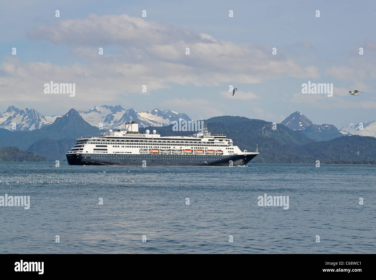 Bateau de croisière naviguant à travers la Kachemak Bay en Alaska avec ses montagnes en arrière-plan Banque D'Images