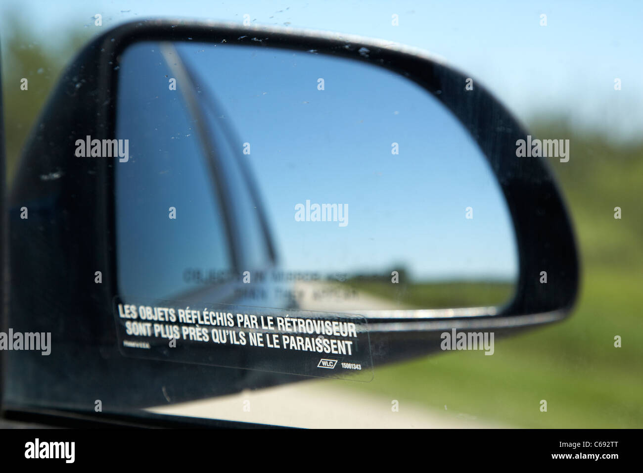 Les objets en miroir sont plus proches qu'ils apparaissent dans le français sur la vitre latérale de la voiture sur l'autoroute Canada Banque D'Images