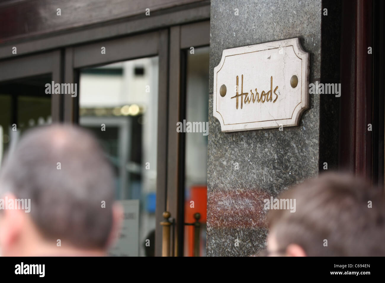 Un Harrods situées sur l'avant de son magasin de Knightsbridge du flou têtes des personnes au premier plan Banque D'Images