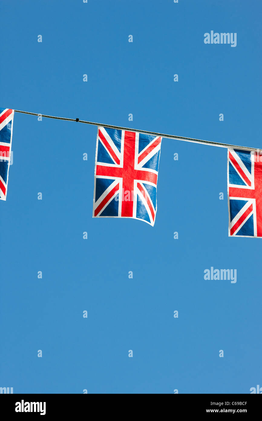 Union Jack flag bunting against a blue sky Banque D'Images