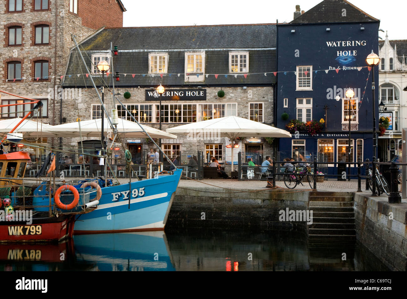 La coque bleu et blanc de l'AF95 bateau de pêche et le point d'eau reflètent dans l'eau à Sutton Harbour, Barbican, Plymouth. Banque D'Images