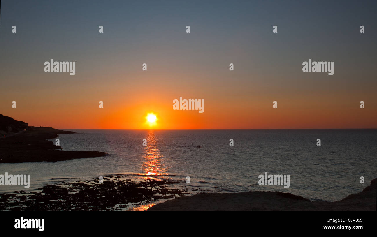 Coucher de soleil depuis le Livre blanc - Bajda Qolla Qolla - Marsalforn, Gozo, Malte à travers Xwejni Bay, vers les marais salants. Banque D'Images