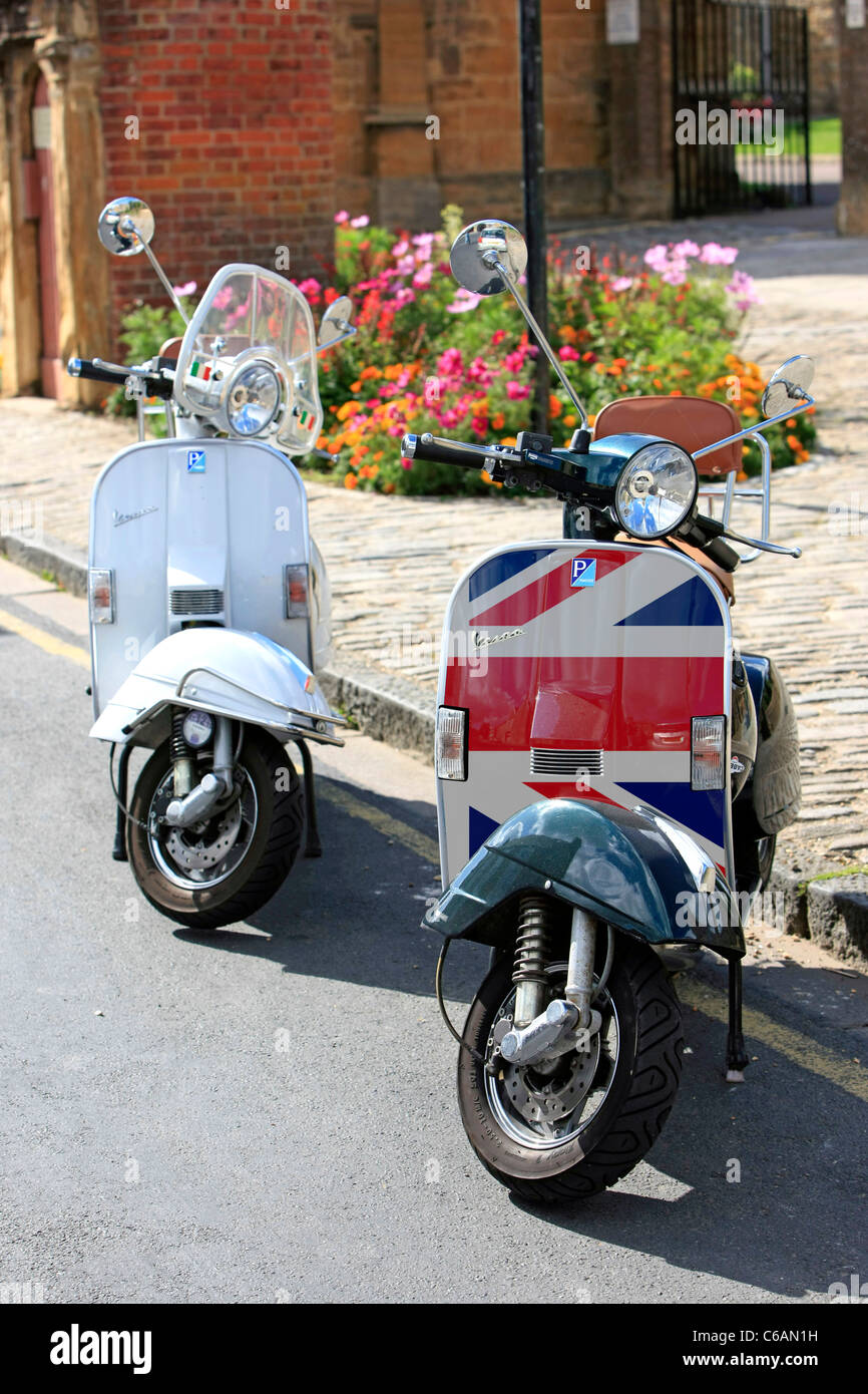 Une paire de scooters Vespa garé au bord de la route en Angleterre Banque D'Images