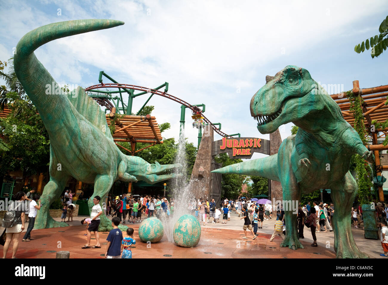 Tourisme asiatique ; les gens à l'attraction Jurassic Park, avec des dinosaures modèles, à Universal Studios, Singapour Asie. Attraction de dinosaures. Banque D'Images