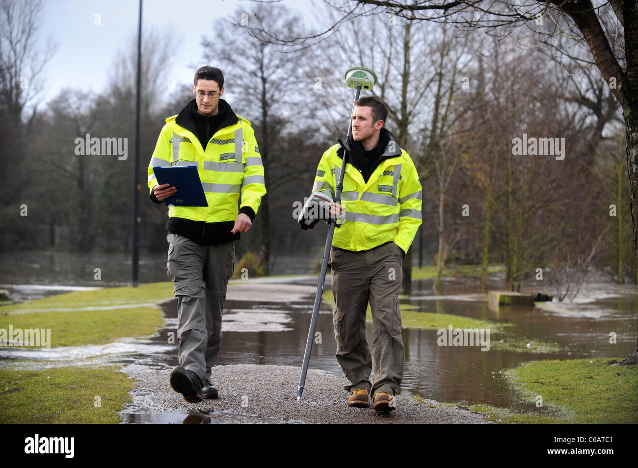 Les agents de l'Agence de l'environnement en utilisant l'équipement GPS pour surveiller les niveaux d'inondation près de Lydney, Gloucestershire UK Banque D'Images