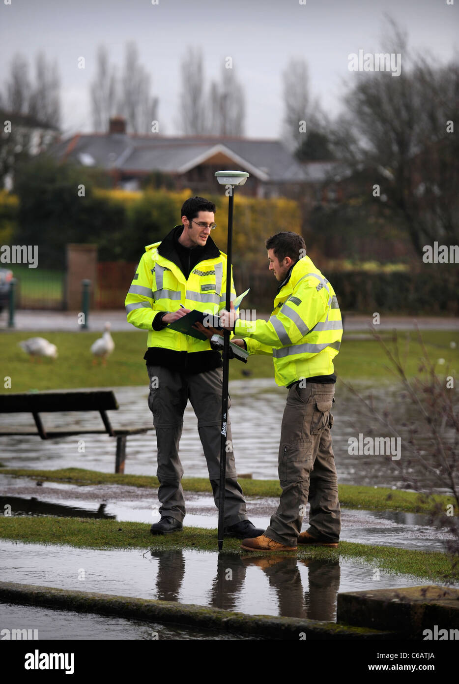 Les agents de l'Agence de l'environnement en utilisant l'équipement GPS pour surveiller les niveaux d'inondation près de Lydney, Gloucestershire UK Banque D'Images
