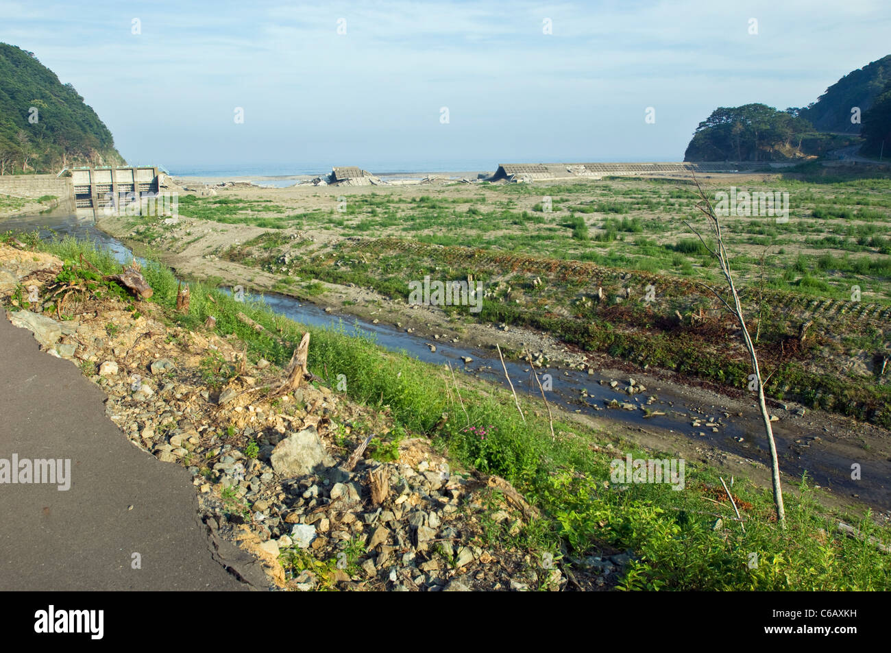 Image montrant des dommages à l'un des obstacles au tsunami Iwate. Notez également les dommages causés à la route à l'avant-plan. Banque D'Images