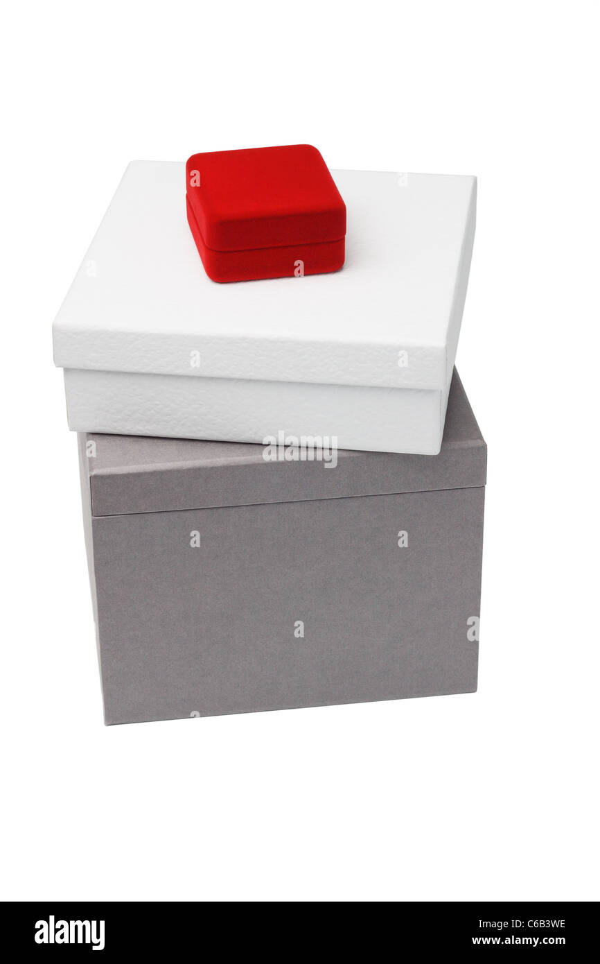 Petite boîte à bijoux rouge assis sur giftboxes sur fond blanc Banque D'Images