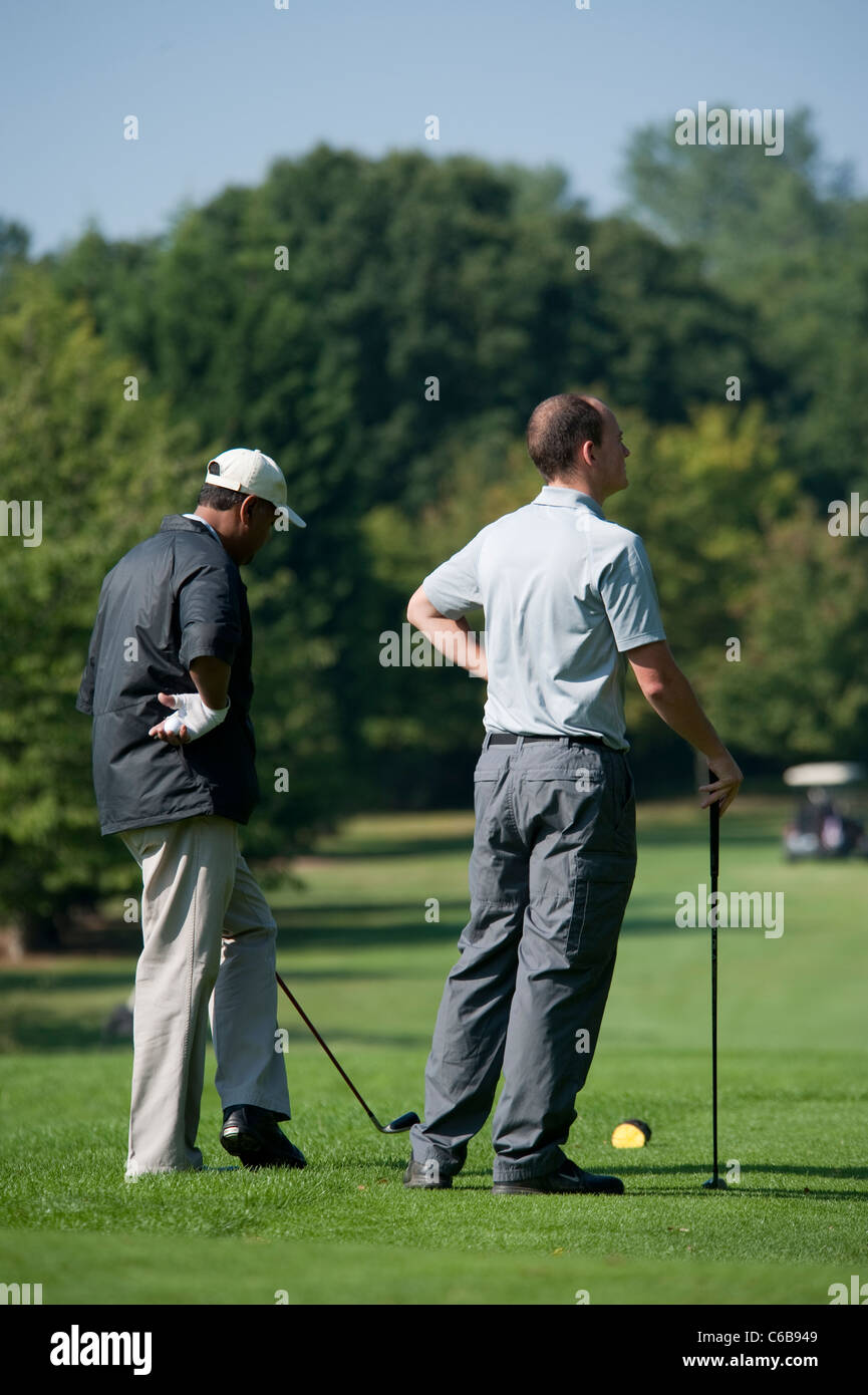 Deux golfeurs attendaient leur tour, vêtu de vêtements de golf sur le green de golf à Stanmore sur une journée ensoleillée en août Banque D'Images