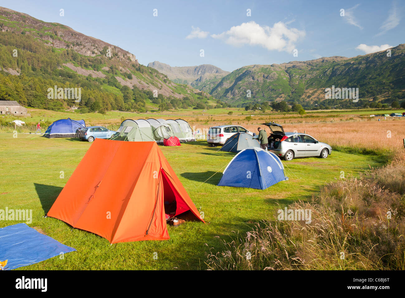Les campeurs sur un terrain de camping à la base Brown ferme dans la vallée de Langdale, regard vers le Langdale Pikes, Lake District, UK. Banque D'Images