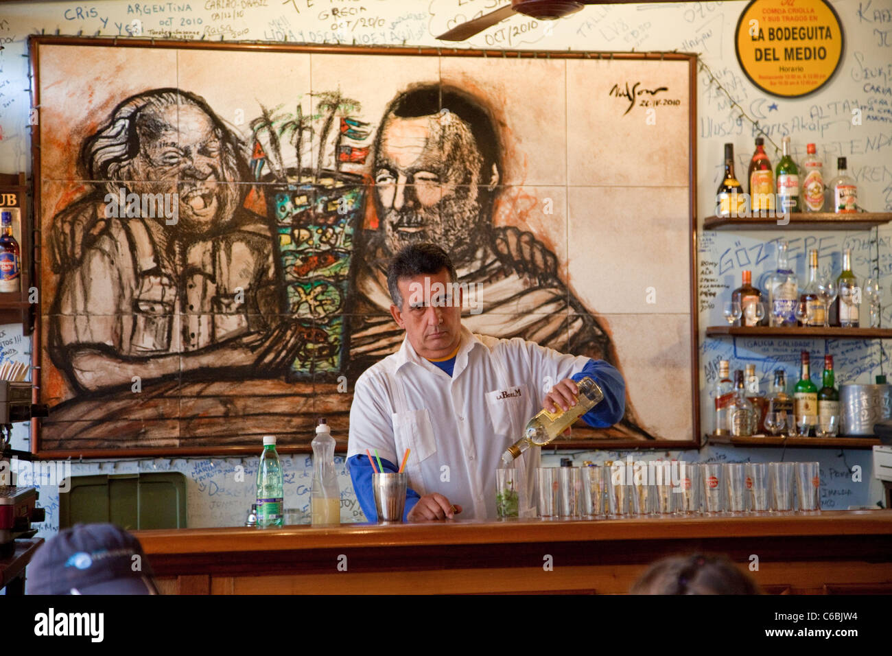 Cuba, La Havane. La Bodeguita del Medio. Barman au travail, mêlant les mojitos. Banque D'Images