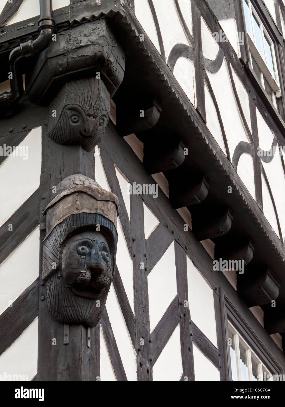 Vue rapprochée de figures en bois sculpté à l'angle de faisceau d'un bâtiment à colombages de style Tudor en Angleterre Warwick UK Banque D'Images