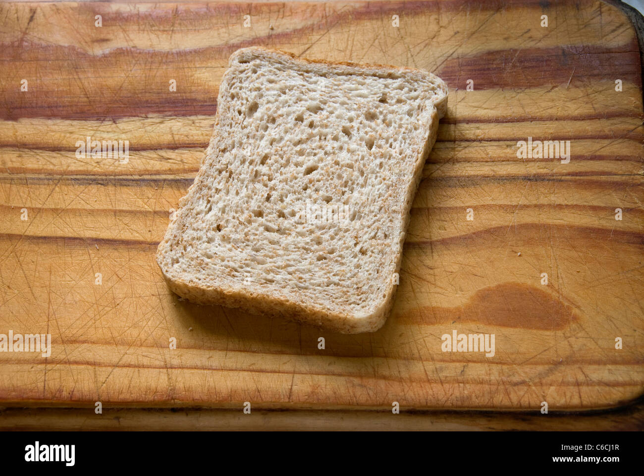 Une tranche de pain frais sur une planche à découper en bois. Banque D'Images
