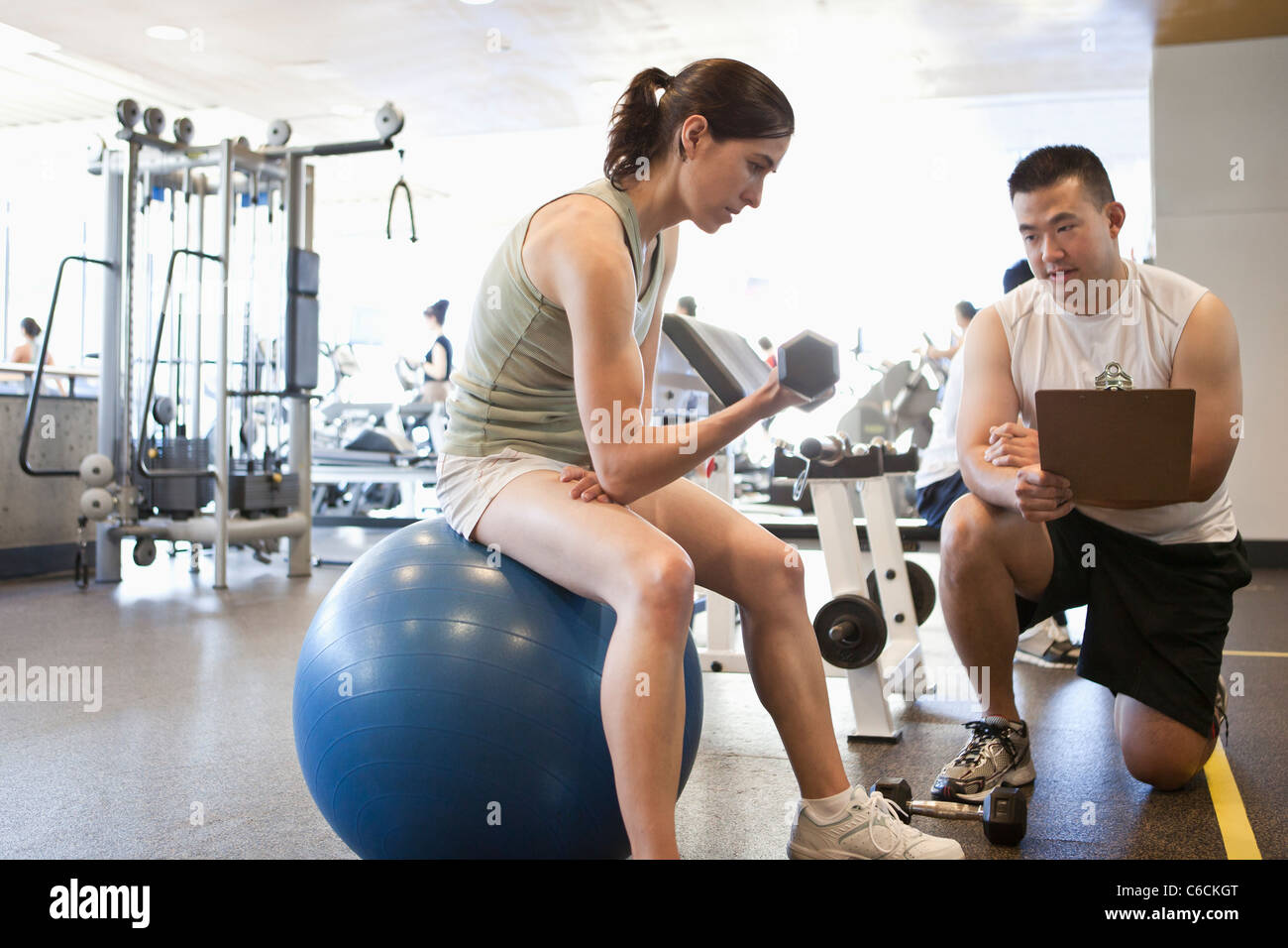 Femme travaillant avec un entraîneur personnel dans le club de santé Banque D'Images