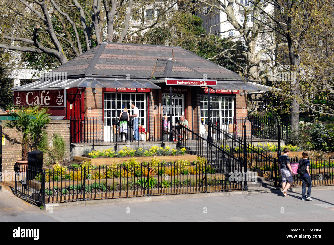 Scène de rue de Londres jusqu'à partir de la route principale à l'extérieur et l'avant de l'Embankment Cafe dans le Victoria Embankment Gardens London England UK Banque D'Images Scène de rue de Londres jusqu'à partir de la route principale à l'extérieur et l'avant de l'Embankment Cafe dans le Victoria Embankment Gardens London England UK Banque D'Images