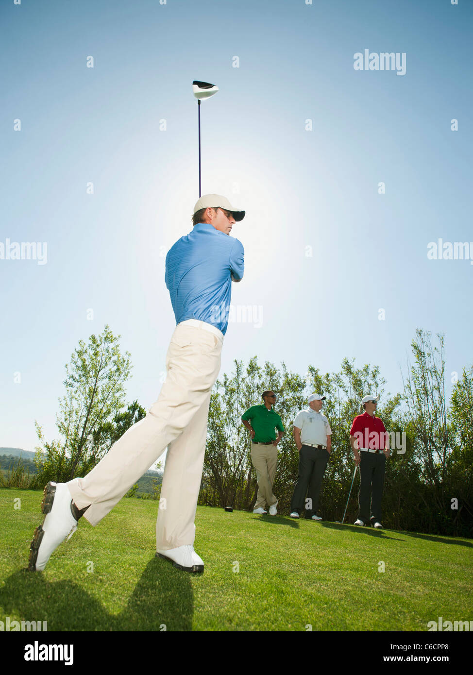 Les hommes jouer au golf ensemble on golf course Banque D'Images