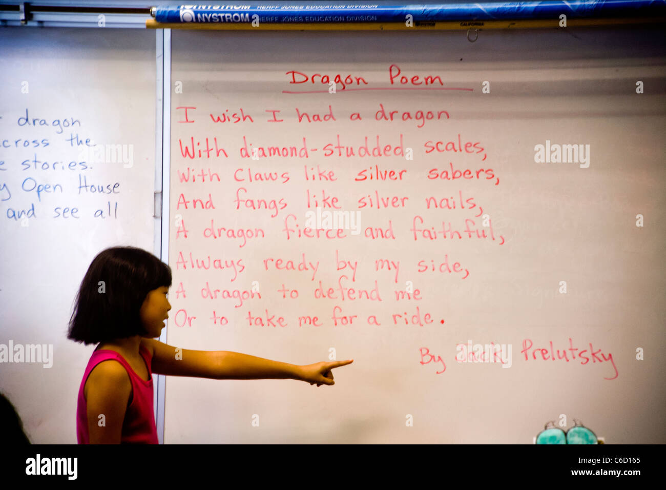 Un jeune étudiant américain asiatique lit un poème sur un dragon à sa classe dans un programme d'apprentissage en été. Banque D'Images