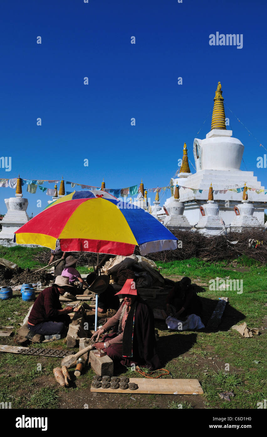 L'argile locale tibétains offrant des comprimés à un temple bouddhiste. Au Sichuan, en Chine. Banque D'Images