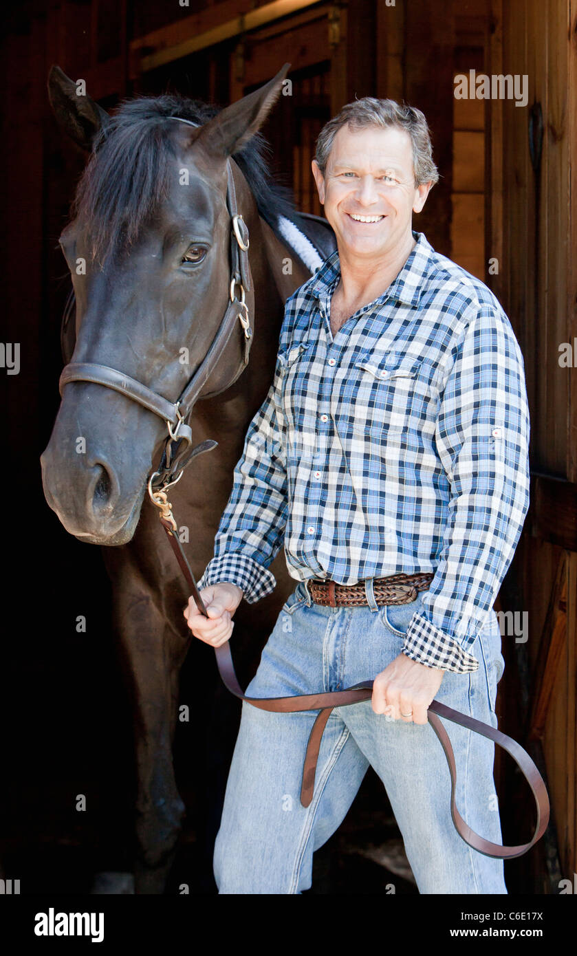 Caucasian man holding horse's bridle Banque D'Images