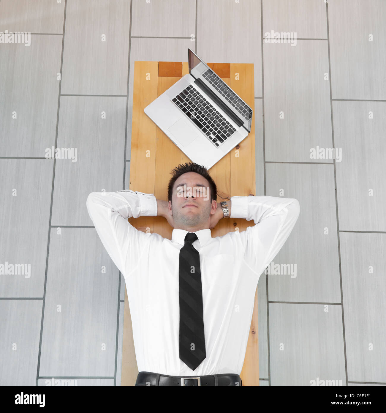 Caucasian businessman sleeping on bench Banque D'Images