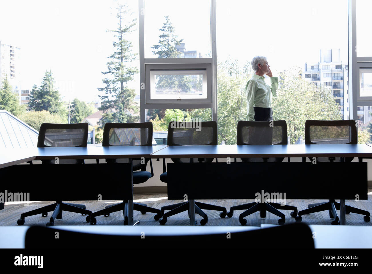 Caucasian businesswoman using cell phone in conference room Banque D'Images