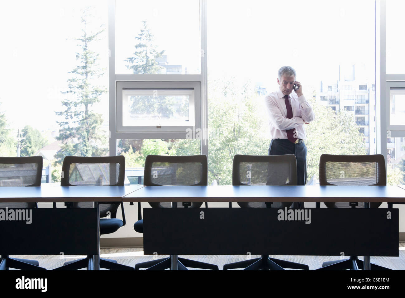 Caucasian businessman using cell phone in conference room Banque D'Images