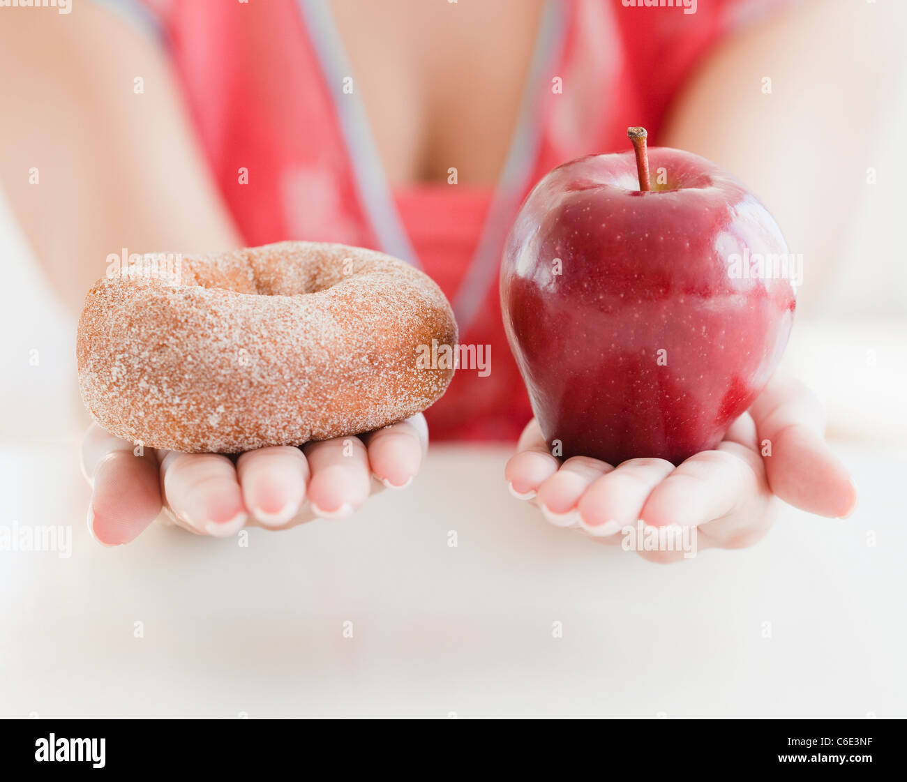 USA, New Jersey, Jersey City, Close up of woman's hands holding donut et Apple Banque D'Images