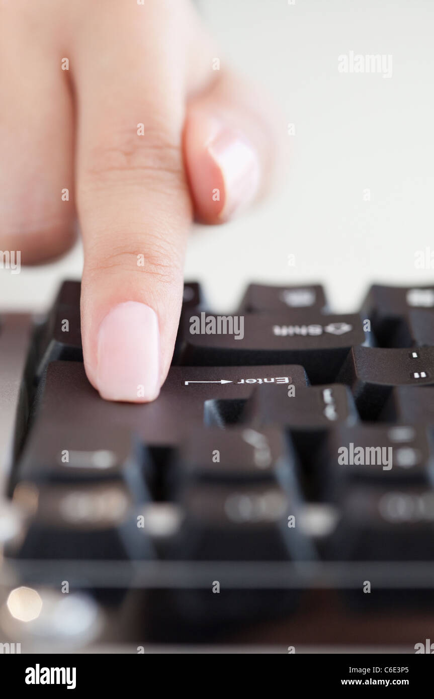 USA, New Jersey, Jersey City, Close up of woman's hand appuyant sur la touche entrée Banque D'Images