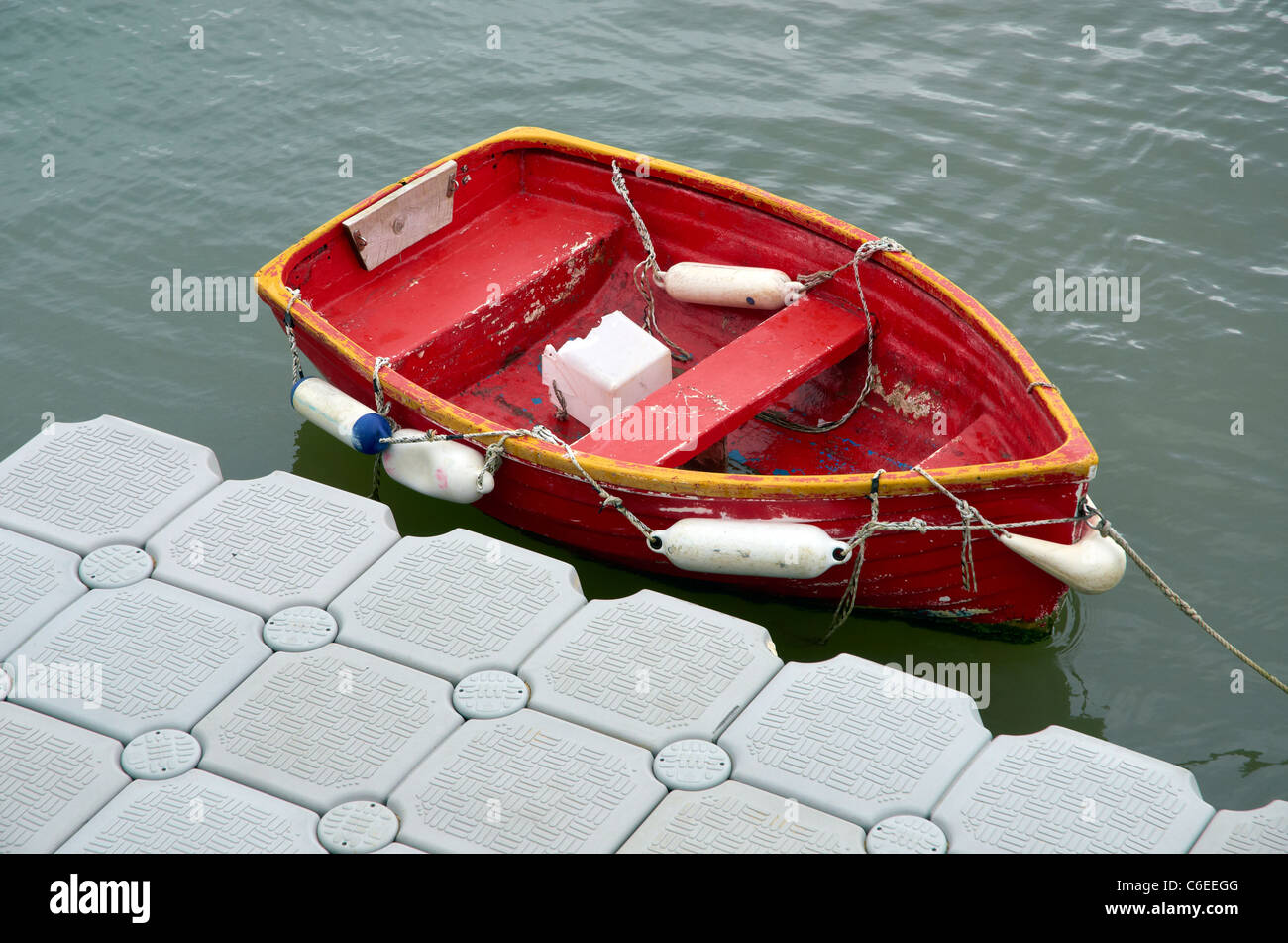 Petit bateau à rames rouge ou canot le long d'un ponton en plastique à la  fin de la Cobb à Lyme Regis, dans le Dorset, Angleterre Photo Stock - Alamy