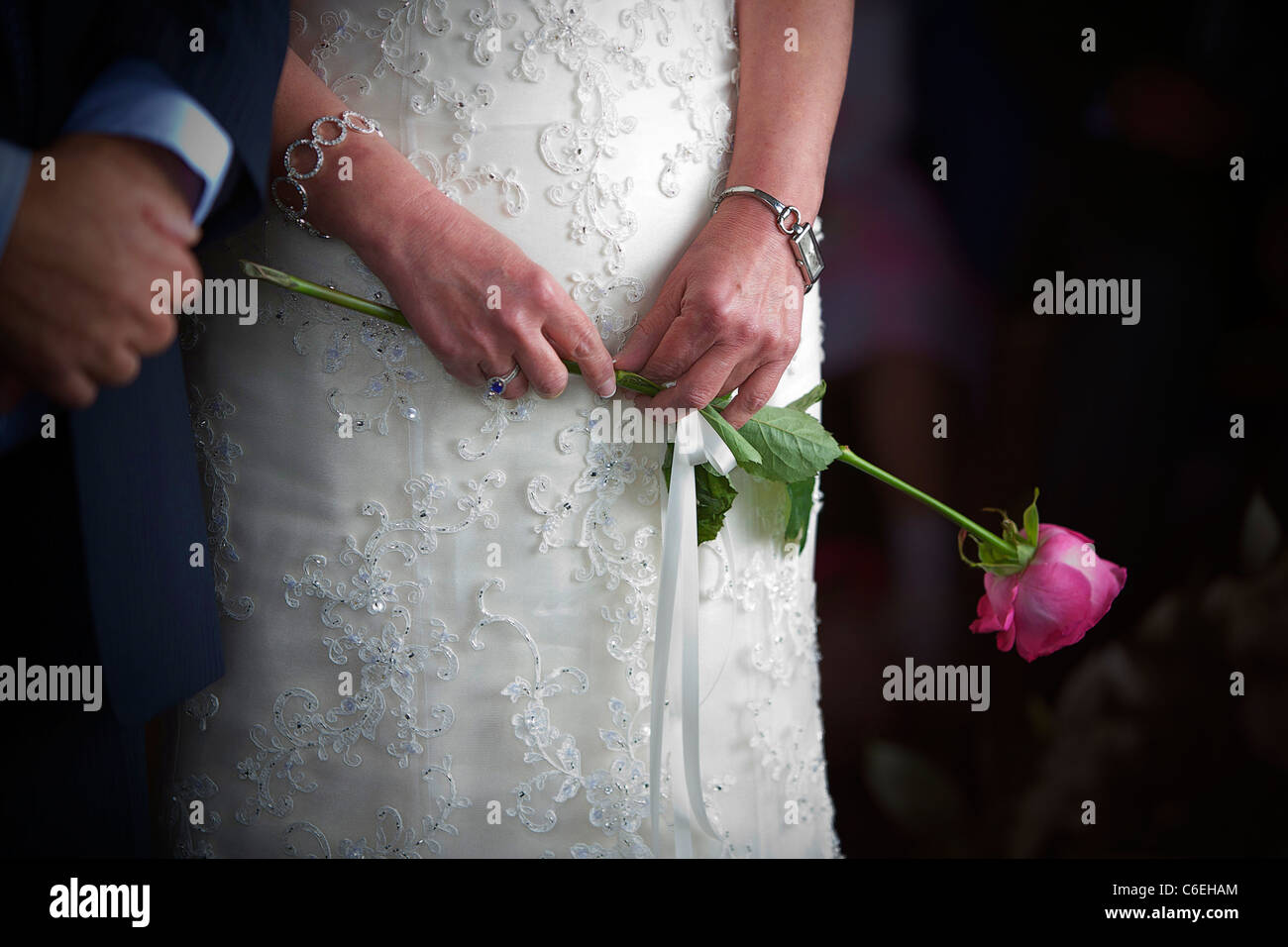 Bride holding son bouquet, une seule rose, le jour de son mariage. Banque D'Images