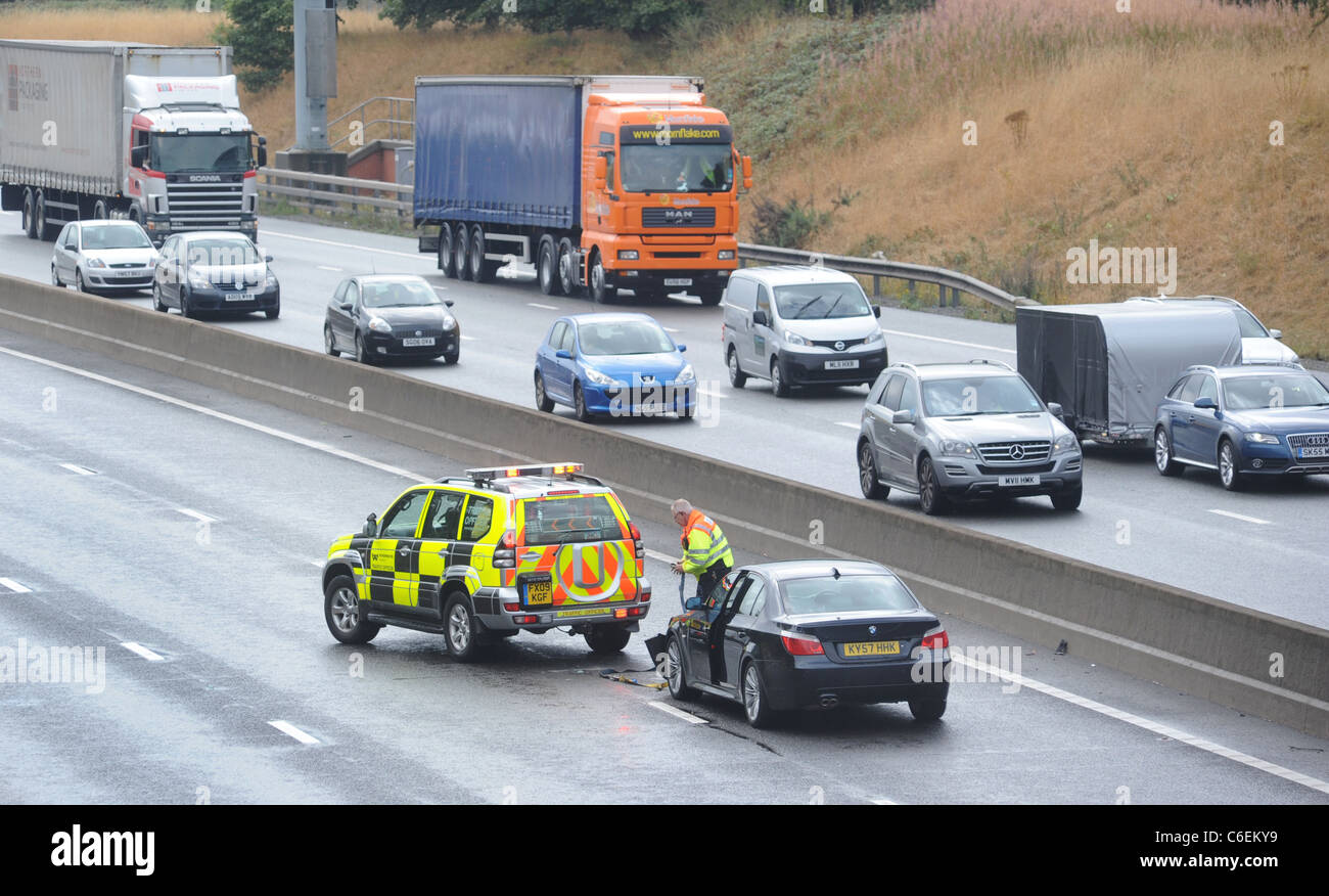Un AGENT DE LA CIRCULATION DE L'Agence routes s'occupe d'un automobiliste EN DÉTRESSE SUR LA VOIE RAPIDE DE L'autoroute M6 À LA SUITE D'UN ACCIDENT UK Banque D'Images