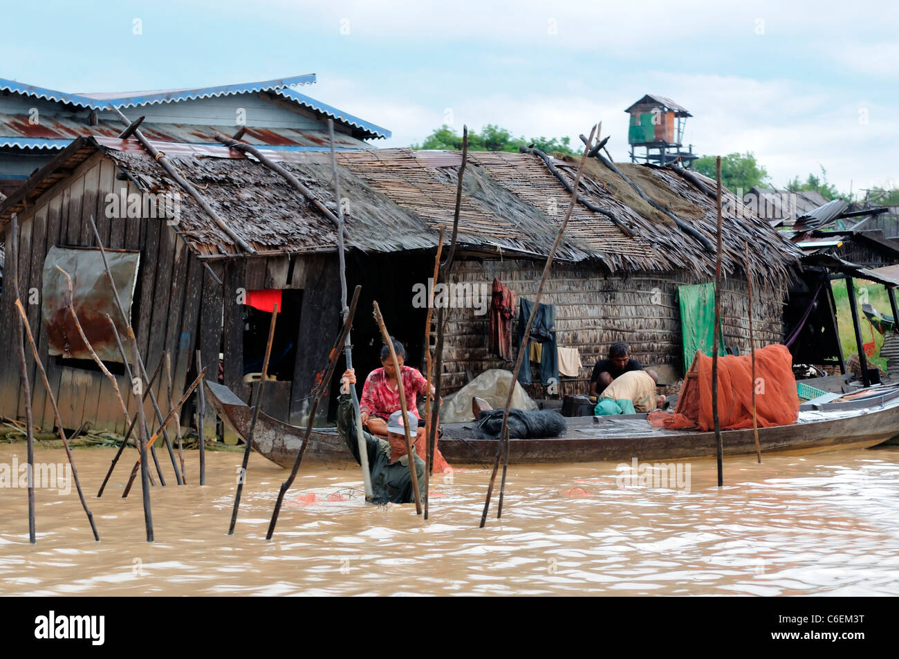 Lac d'eau douce de Tonle Sap siem reap cambodge femme debout stand jusqu'à l'eau à l'aide de poteaux en fond du lac Banque D'Images