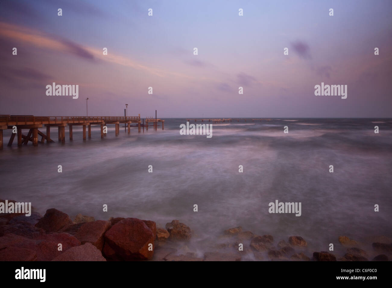 Tôt le matin, la lumière avec les nuages de tempête à la jetée de pêche sur Seawall Boulevard, Galveston, Texas, la Côte du Golfe Banque D'Images