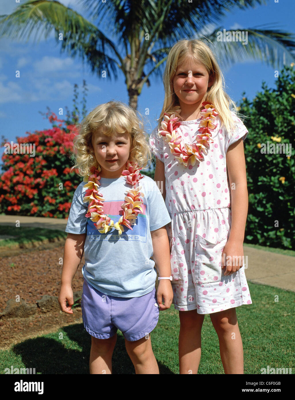 Les enfants portant des leis en hotel garden, Maui, Hawaii, United States of America Banque D'Images